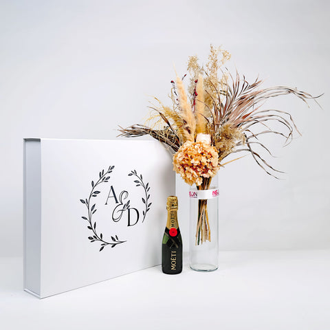 Elegant large gift box featuring flowers and a bottle of champagne