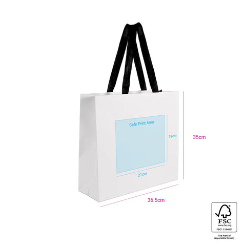 Image of White tote bag with black handles and a blue label on a white background