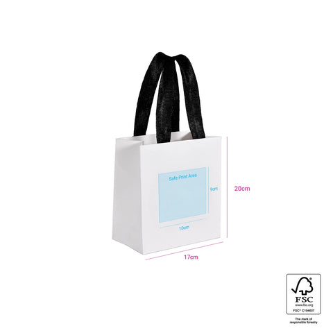 Image of White gift bag with black handles and a blue label on a white background