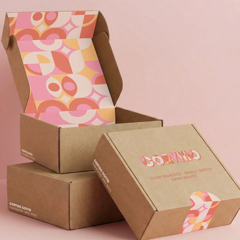 Image of Cardboard coffee boxes with a colorful pattern on a pink background