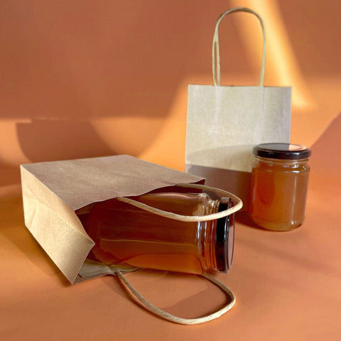 Image of brown paper bags with a jar of honey