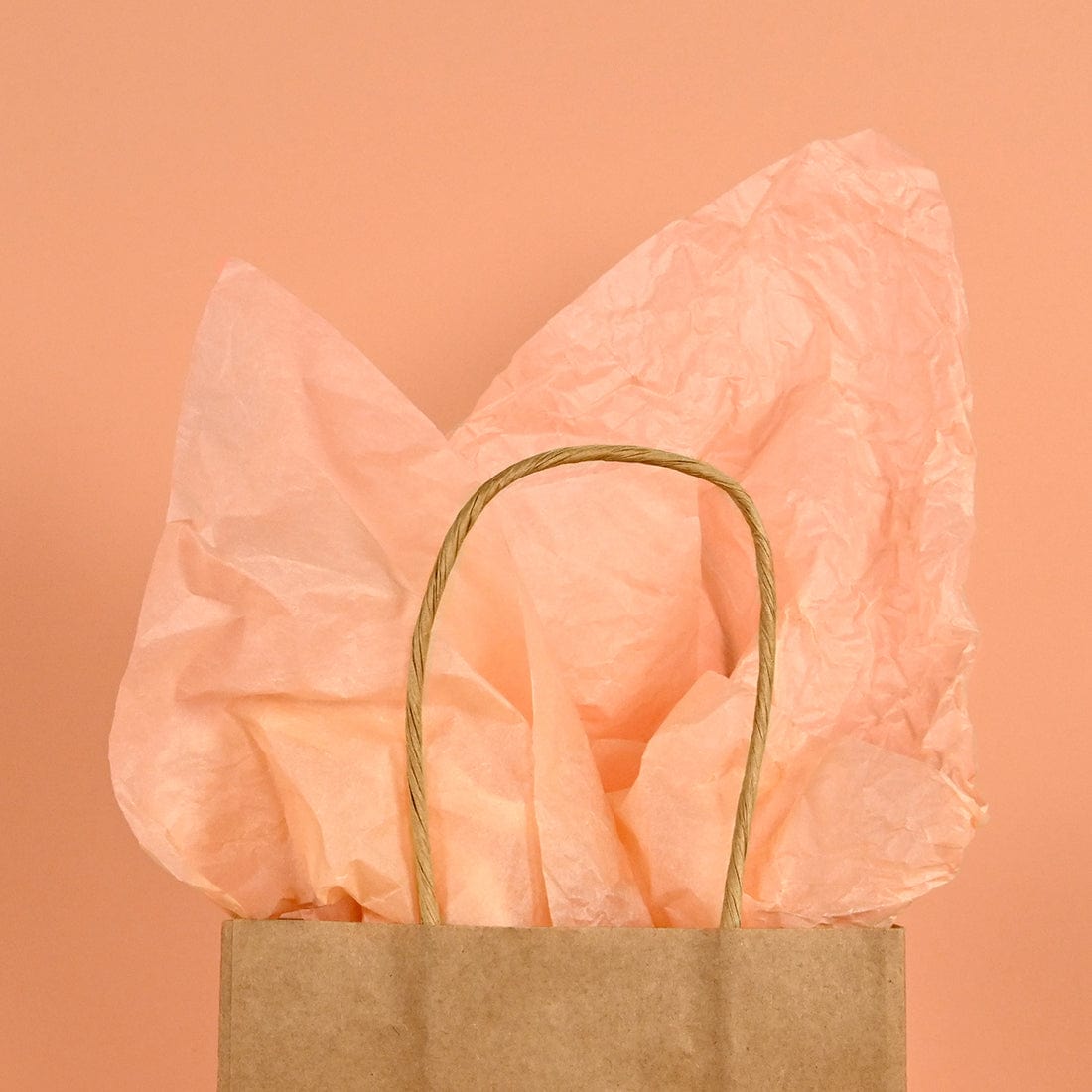 peach coloured tissue paper in kraft paper bag